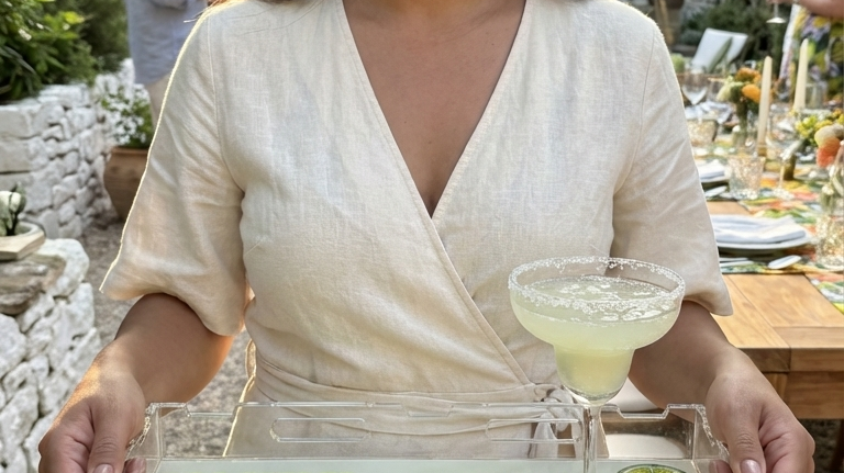 Woman serving cocktails on an acrylic serving tray at a patio and pool party